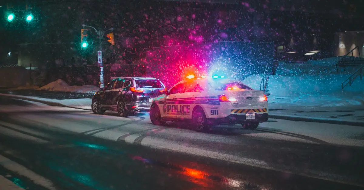 A police car with flashing lights on a snowy road at night