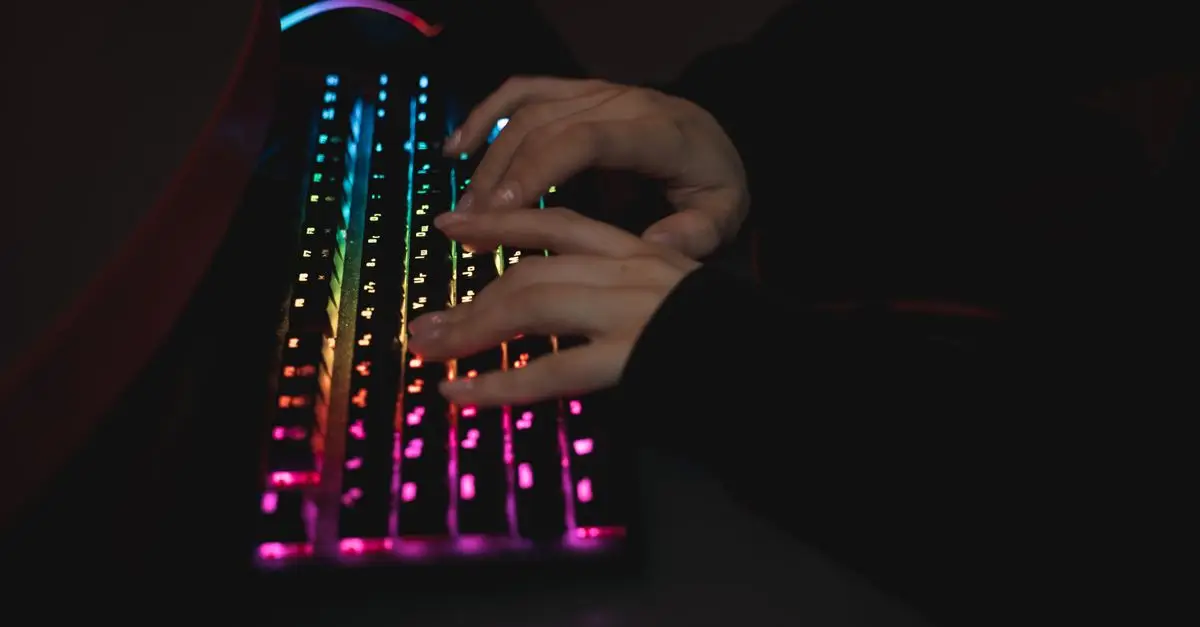Hands typing on an RGB keyboard in the dark