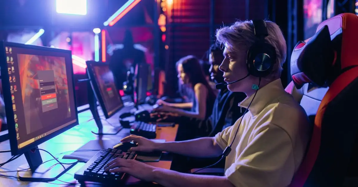 A player with a headset talking to teammates at a gaming PC