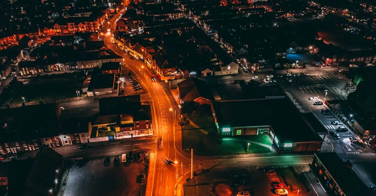 A city at night seen from above, streets lit orange