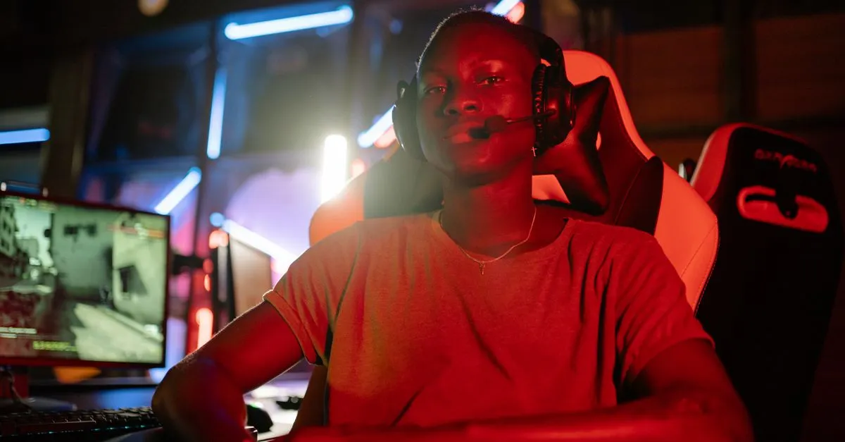A focused gamer wearing a headset in a neon-lit room, ready for action.